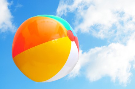 Colorful beach ball up in the air with beautiful blue sky