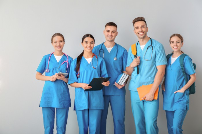 Group of medical students on light background