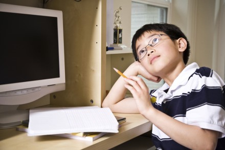 A shot of an asian kid studying at home