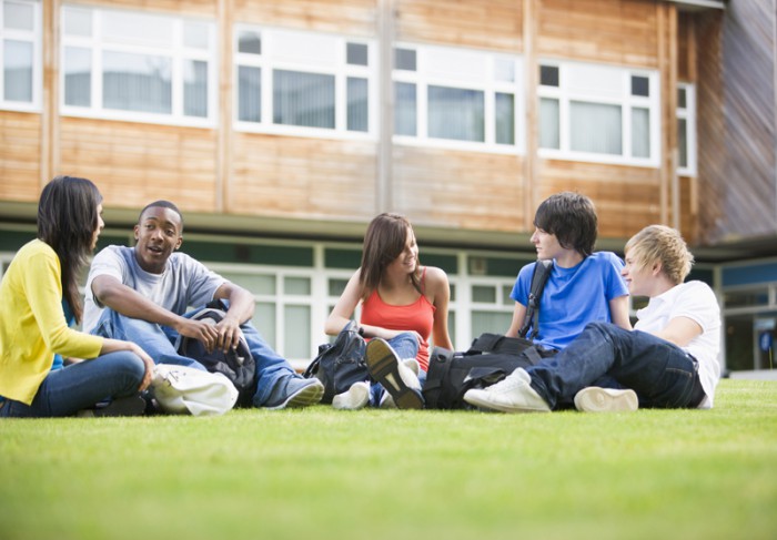 College students sitting and talking on campus lawn