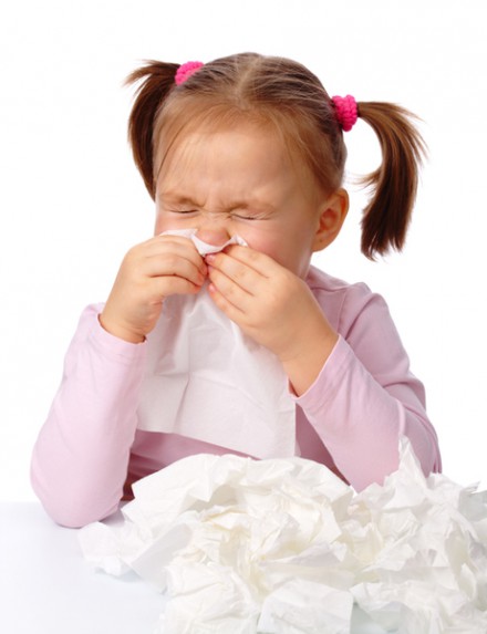 Little girl blows her nose, isolated over white