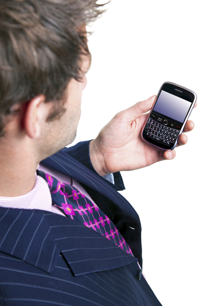 Overhead shot of a man using a mobile phone organiser, screen has a clipping path to add your own message or image. The device has been significantly altered from the original product.
