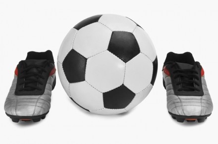 Close-up of a soccer ball with a pair of shoes